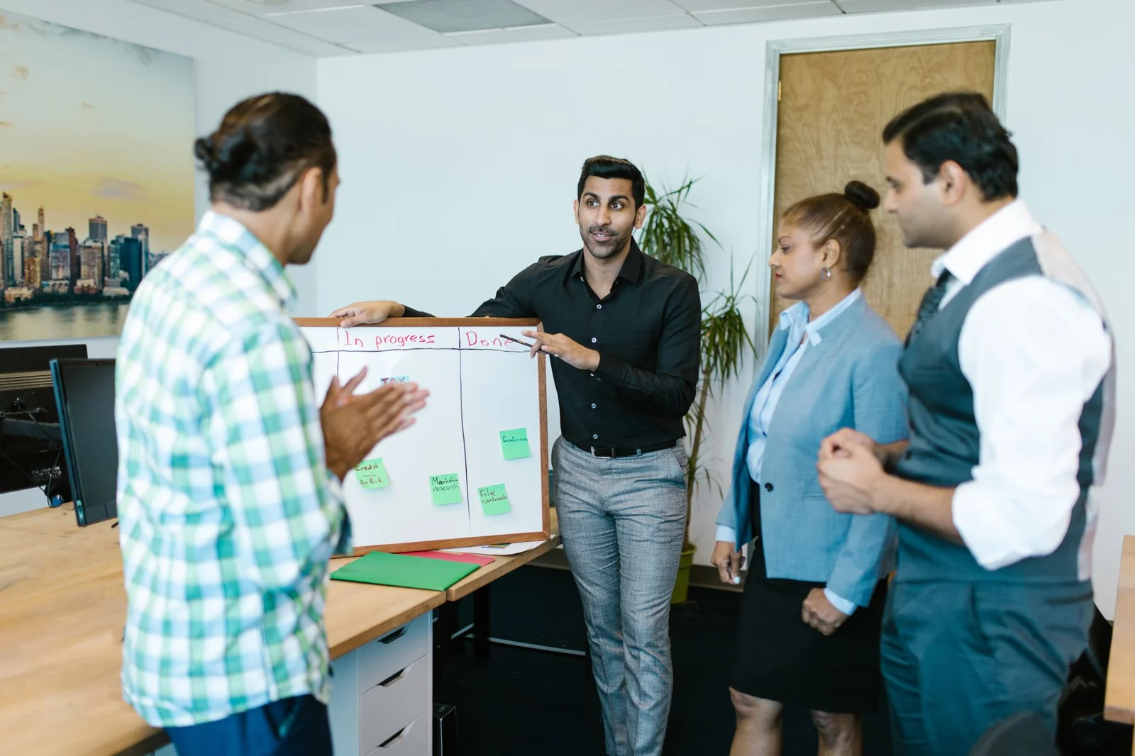 A team talking through a task at a whiteboard